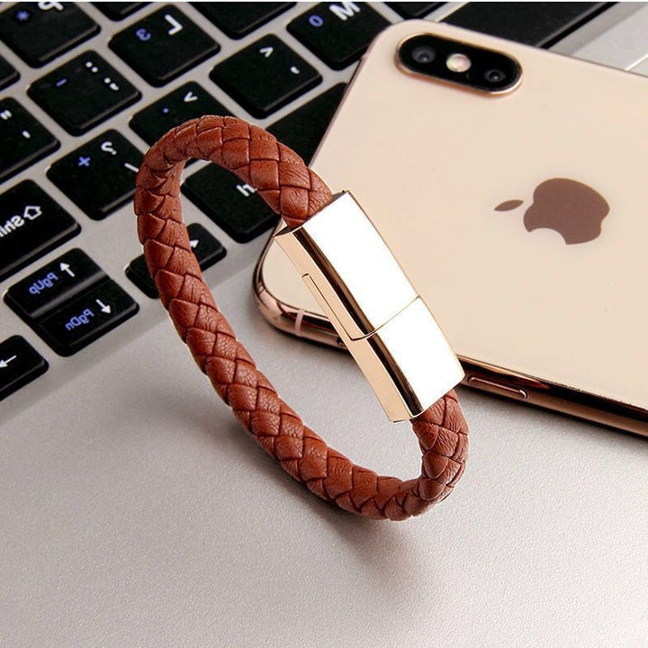 Brown braided USB drive on a laptop keyboard with an iPhone in the background
